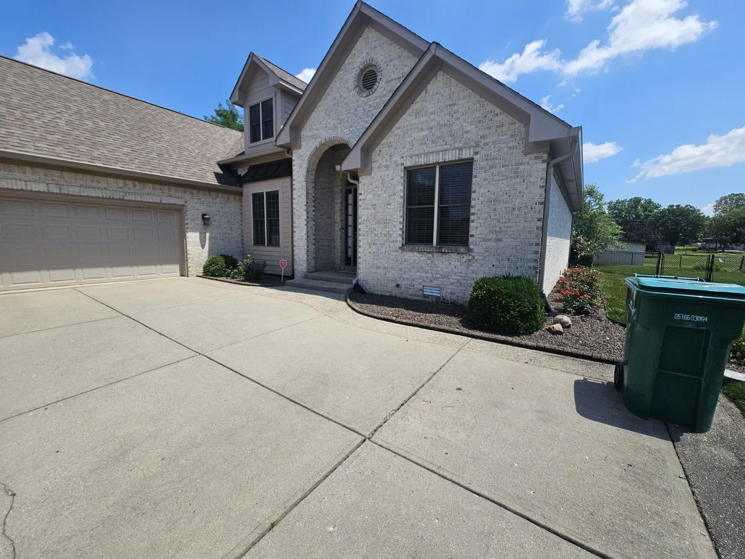 Finished seamless gutter replacement on a white brick Indianapolis home