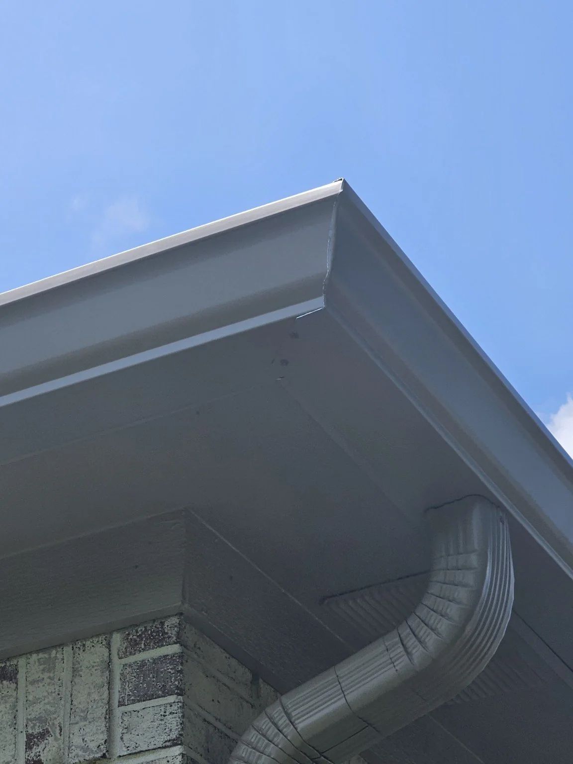 Gray 6-inch style seamless gutter and downspout at an Indianapolis home eave